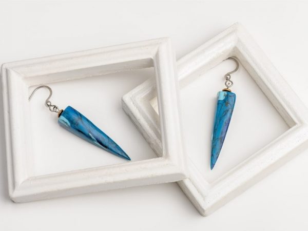 Légères et élégantes les boucles d'oreilles Ursula ont une forme de pyramide et un motif pierre de turquoise les crochets d'oreilles sont en acier inoxydable de bijouterie argenté